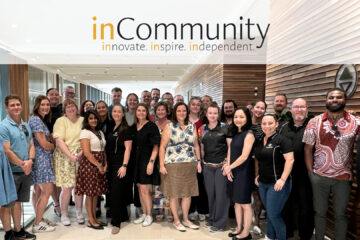 Group photo of inCommunity Inc team members gathered together in event space.