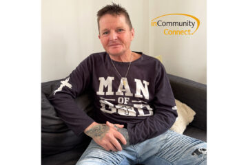 Christian sits on a couch smiling with inCommunity Connect logo in the top right hand corner.